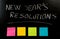 New Year resolutions written with chalk on blackboard with blank colorful post its memo notes