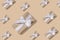 New Year`s composition. Trendy New Year pattern of gift boxes in paper with a white ribbon with a hard shadow on a sand-colored