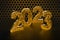 New Year`s Eve hive with bee on honey comb  Shiny hexagonal gold number 2023 on a black background with bee