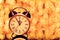 New year`s eve midnight. Retro alarm clock whose pointer shows five to twelve on festive bokeh background