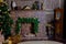 New Year`s fireplace with decorative spruce with gifts in front of him and scattered pillows on the carpet