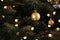 New Year\\\'s golden colored toys and garland hang on a natural Christmas tree. Close-up and soft focus