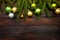 New Year`s greens, yellow and silver balls with live fir branches on a wooden background. Top view