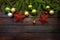 New Year`s greens, yellow and silver balls together with red stars and with live fir branches on a wooden background. Top view