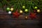 New Year`s greens, yellow and silver balls together with red stars and with live fir branches on a wooden background. Top view