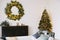 New Year`s interior. Decorated Christmas tree with gifts. Wreath of spruce with garland. Christmas decorations