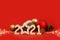 New Year`s layout. Christmas card with 2021 numbers, new year balls, fir cones and bokeh on red background. Side view