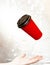 New Year`s lighting bokeh, hand with red paper cup for coffee flying