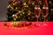 New Year`s photo numbers 2021 and glasses on a red table with champagne on the background of the Christmas tree with lights and