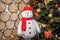 New Year\\\'s soft toy white snowman near the Christmas tree on a wooden background