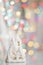 New Year`s souvenir White ceramic house on a background of multi-colored bokeh. Merry Christmas or Happy New Year