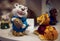 New Year`s toys. Figurine white lion cub piggy bank with a barrel of money in his hands in a blue sweater and a figurine of a red