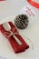 New year table decoration in minimal style, red napkin, dessert spoon and pine cone with greeting text `Welcome 2019`