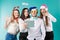 New Year theme Christmas winter office company employees. Group 4 young Caucasian people business smile holiday funny hats
