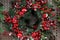 New year wreath of red berries and green leaves and needles in white artificial snow