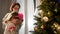 New Year. Young Mother Comforts Little Girl Upset Standing Near Christmas Tree.