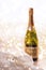 New Years Eve holiday champagne bottle and a gift box and shiny snow on marble background