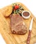 New York beef steak with garnish on bamboo plate