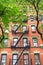 New York City brick apartment building in spring surrounded by green trees.