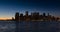 New York City Financial District and East River with passing boats at twilight
