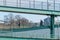 New York City, NY/USA - 3/19/2019: People walking an jogging along a steel structure next to the East River, with the