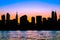 New York City skyline with silhouetted buildings and colorful sunset sky