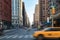 New York City street scene with yellow taxi cab and people crossing Broadway in Manhattan, New York City