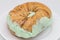 New York City Style Cinnamon Raisin Bagel with Pistachio Cream Cheese on a White Plate