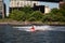 New York, City / USA - JUL 10 2018: Man wearing clown suite riding jet ski water bike in East River under Manhattan Bridge