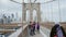 New York City, USA - OKTOBER, 2016: Tourists walk and make photo on the famous Brooklyn Bridge in New York City