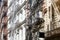 New York houses facades with fire escape stairs, sunny day