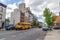 New York neighborhood with buildings and trees and vehicles on the marked  road