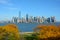 NEW YORK, NY - 04 NOV 2019: The Manhattan Skyline seen from Ellis Island with beautiful fall trees in the foreground