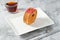 New York roll or round croissant with marmalade with tea on stone table