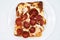 New York Style Sicilian Pepperoni Slice of Pizza on a White Plate