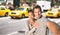 New York travel selfie tourists couple taking photo on NYC city street summer holiday vacation with yellow taxi cabs in