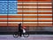 New York, United States, USA March 24, 2020: heoric essential worker with protective mask riding bicycle in front of