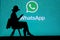 NEW YORK, USA, 25. MAY 2020: WhatsApp cross-platform messaging and Voice over service Young woman silhouette sitting on chair and