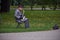 New York, USA - July, 2017: old man in a raincoat and a hat plaing saxophone in a park