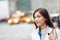 New Yorker woman walking on New York City street waiting for car lift rideshare taxi. Asian young professional with