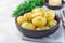 New young boiled  potato topped with melted butter and chopped dill in ceramic bowl, horizontal, copy space