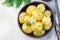 New young boiled  potato topped with melted butter and chopped dill in ceramic bowl, horizontal,  top view, copy space