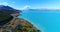 New Zealand aerial drone footage of lake Pukaki and southern alps on South Island. Road and clear blue lake with Aoraki