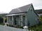 New Zealand: Akaroa historic 19th century grey cottage with verandah