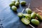 New Zealand exotic food. Berry nergi, or small kiwi. Grey stone background. Baby kiwi or mini kiwi fruits on stone background.