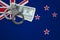 New Zealand flag with handcuffs and a bundle of dollars. The concept of breaking the law and thieves crimes