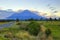 New Zealand landscape with farmland and grazing cows on background volcano Taranaki