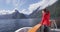 New Zealand Milford Sound tourist on travel on Cruise ship in Fiordland National Park. Woman enjoying boat tour and