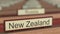 New Zealand name sign among different countries plaques at international organization. 3D rendering