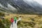 New Zealand trampers backpacking on Mount Cook / Aoraki Hooker valley travel. hikers hiking walking on Hooker Valley